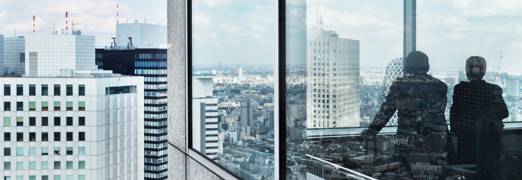 People in an office building looking out over Tokyo